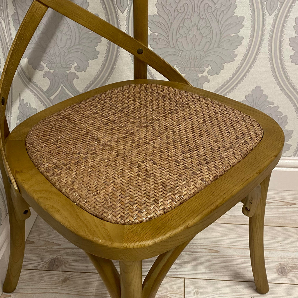 Oak dining chair with woven seat and rounded back, warm golden finish.