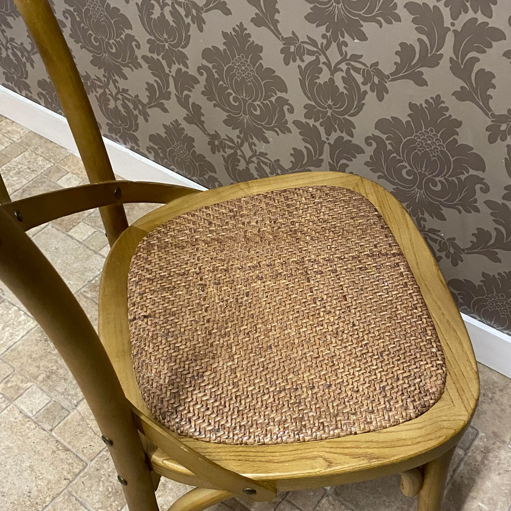 Woven fabric seat on oak dining chair with rounded wooden frame, warm finish.