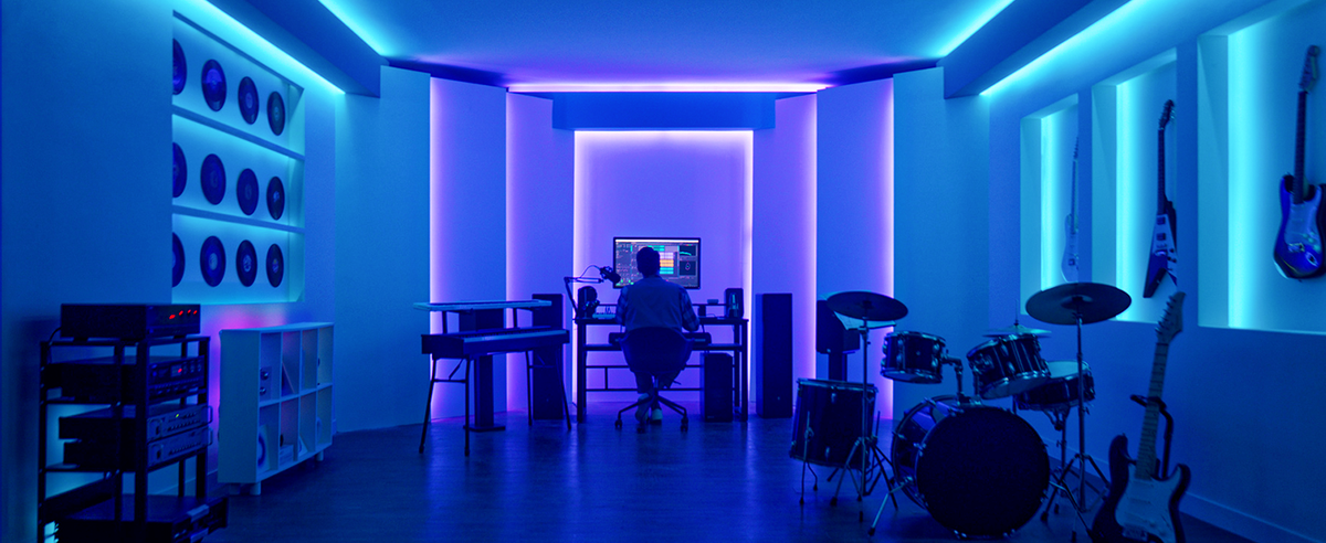 RGBIC LED strip light creating a continuous blue strip along a studio wall
