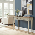 Cream console table with two drawers, fluted legs, and ornate drawer pulls