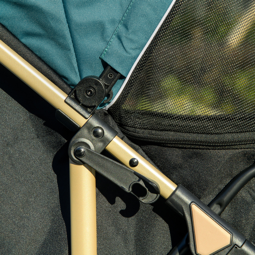 Pet stroller frame close-up with locking mechanism on light wood bar and dark fabric