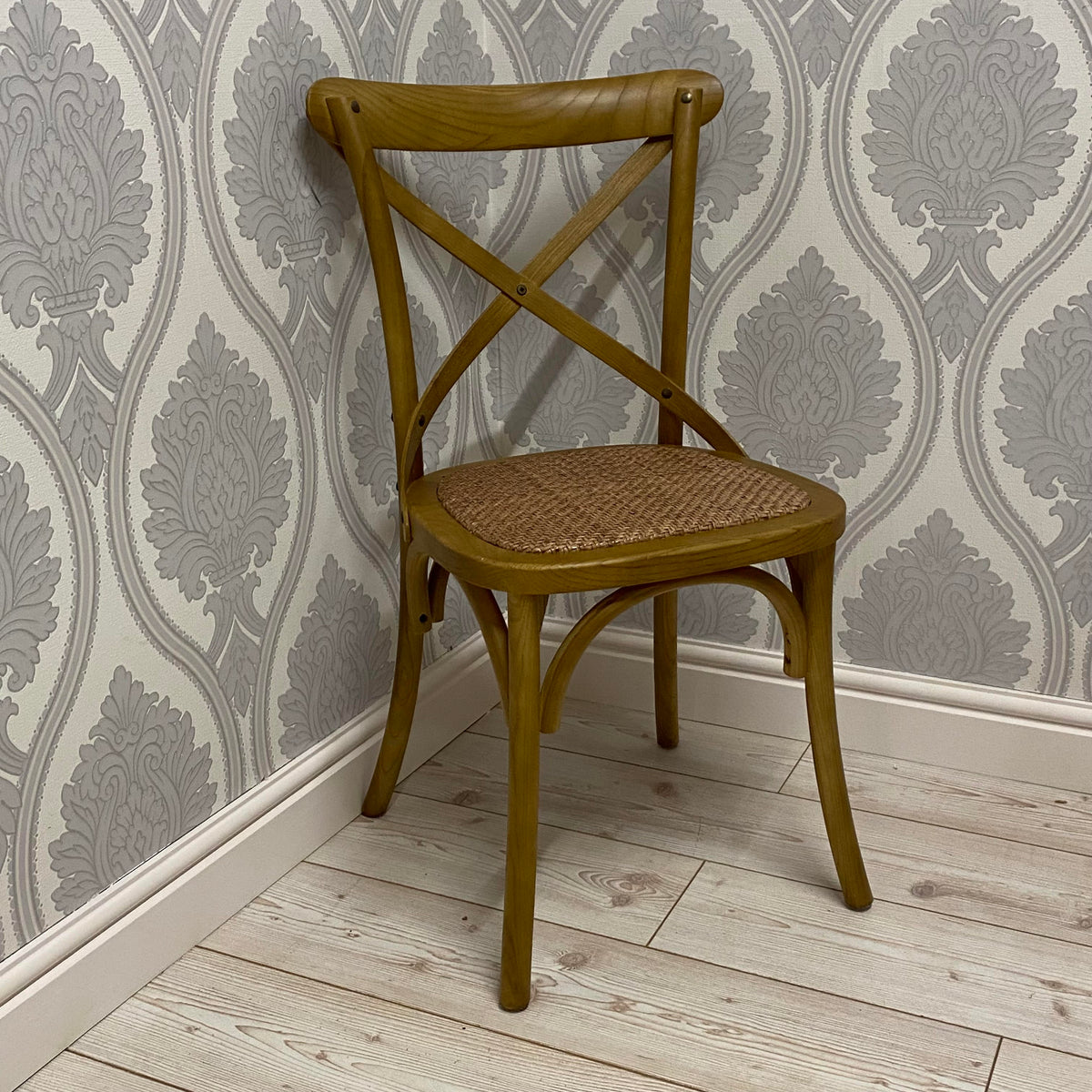 Oak cross-back dining chair with woven fabric seat and warm golden finish.