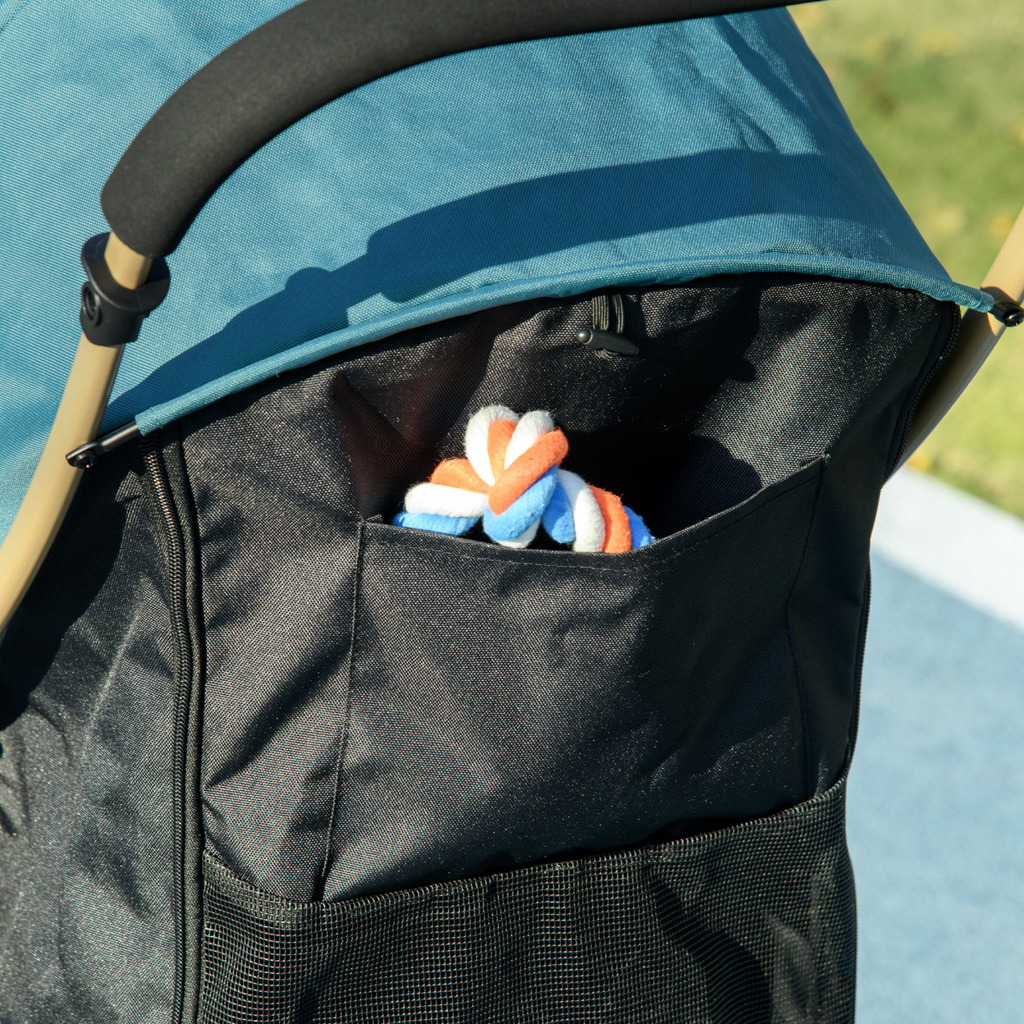 Pet stroller storage basket with dark mesh sides and teal fabric top, small toys inside