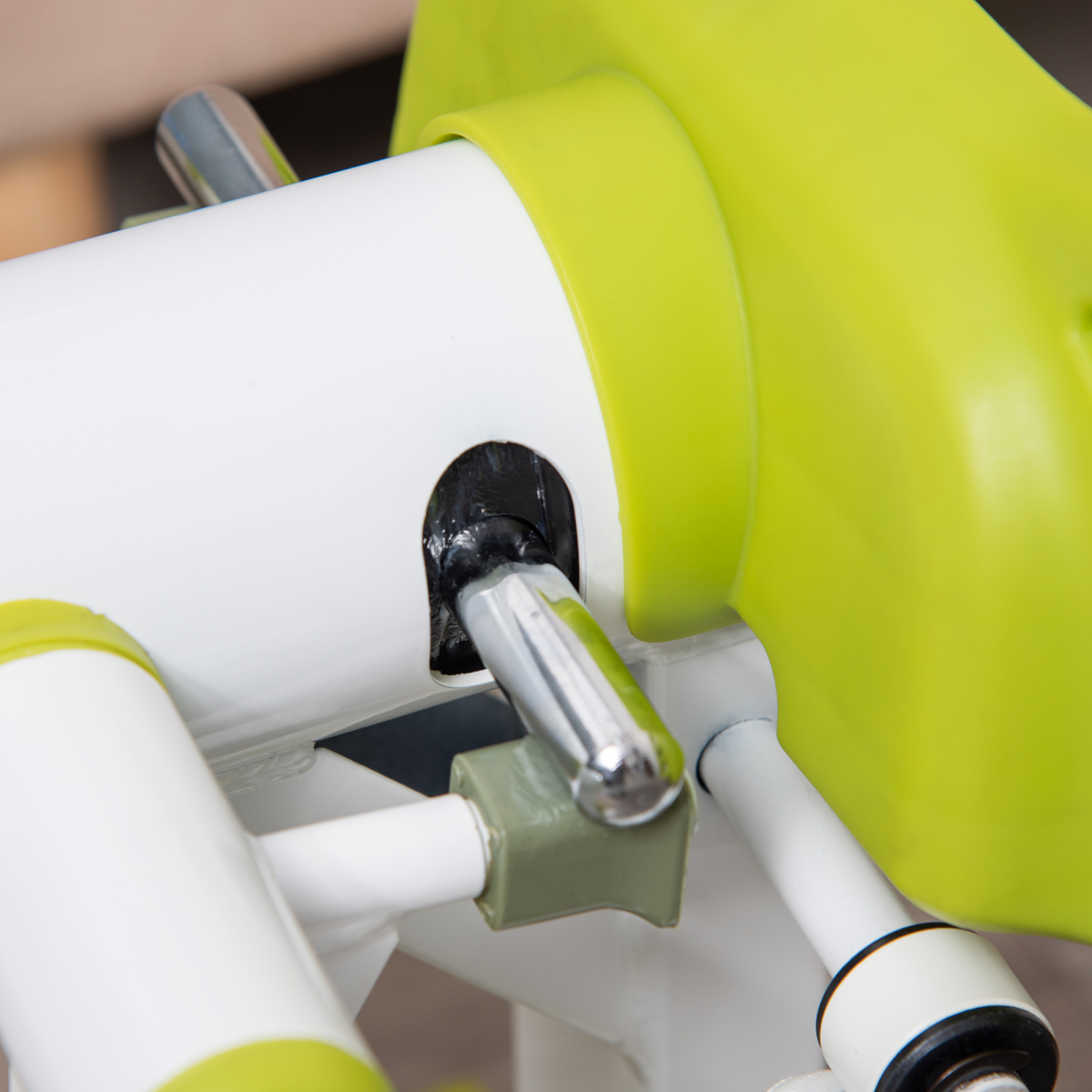 Mini stepper close-up of silver pivot joint connecting white bars and green base parts