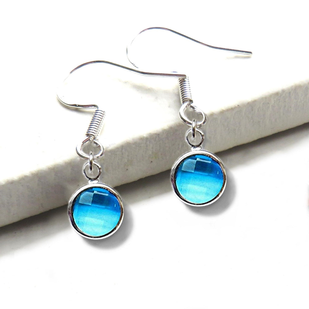 Pair of blue round drop earrings with silver frames and fishhook backs