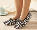 Zebra print fleece slip-on slippers with bow ties, women's pair